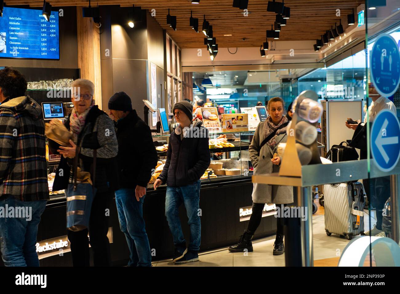 Munich,Germany- February 20,2023: People stand in line to buy breakfast at a bakery in Munich airport. Stock Photo