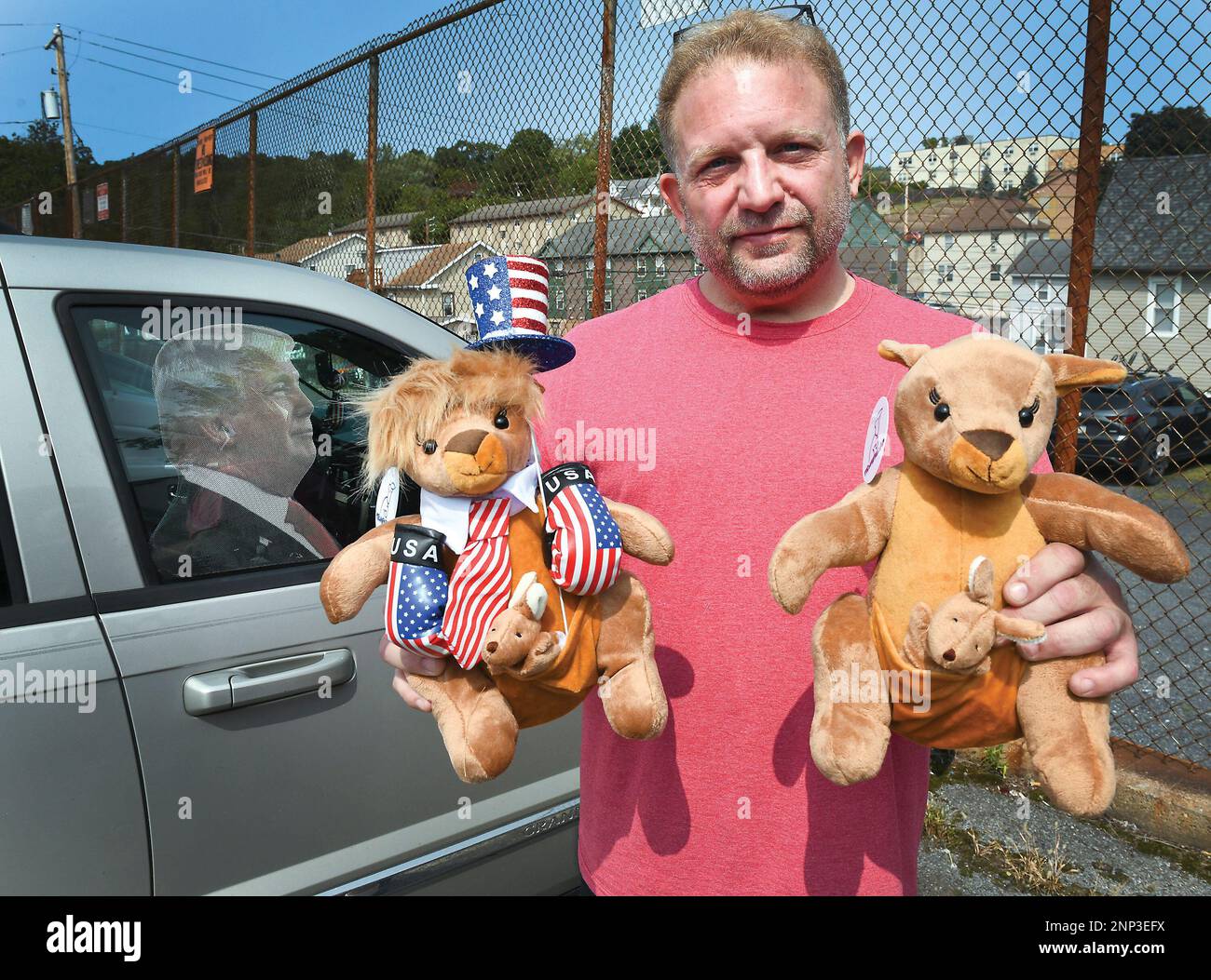 Ben Philips shows off two of his Trump kangaroos outside his apartment