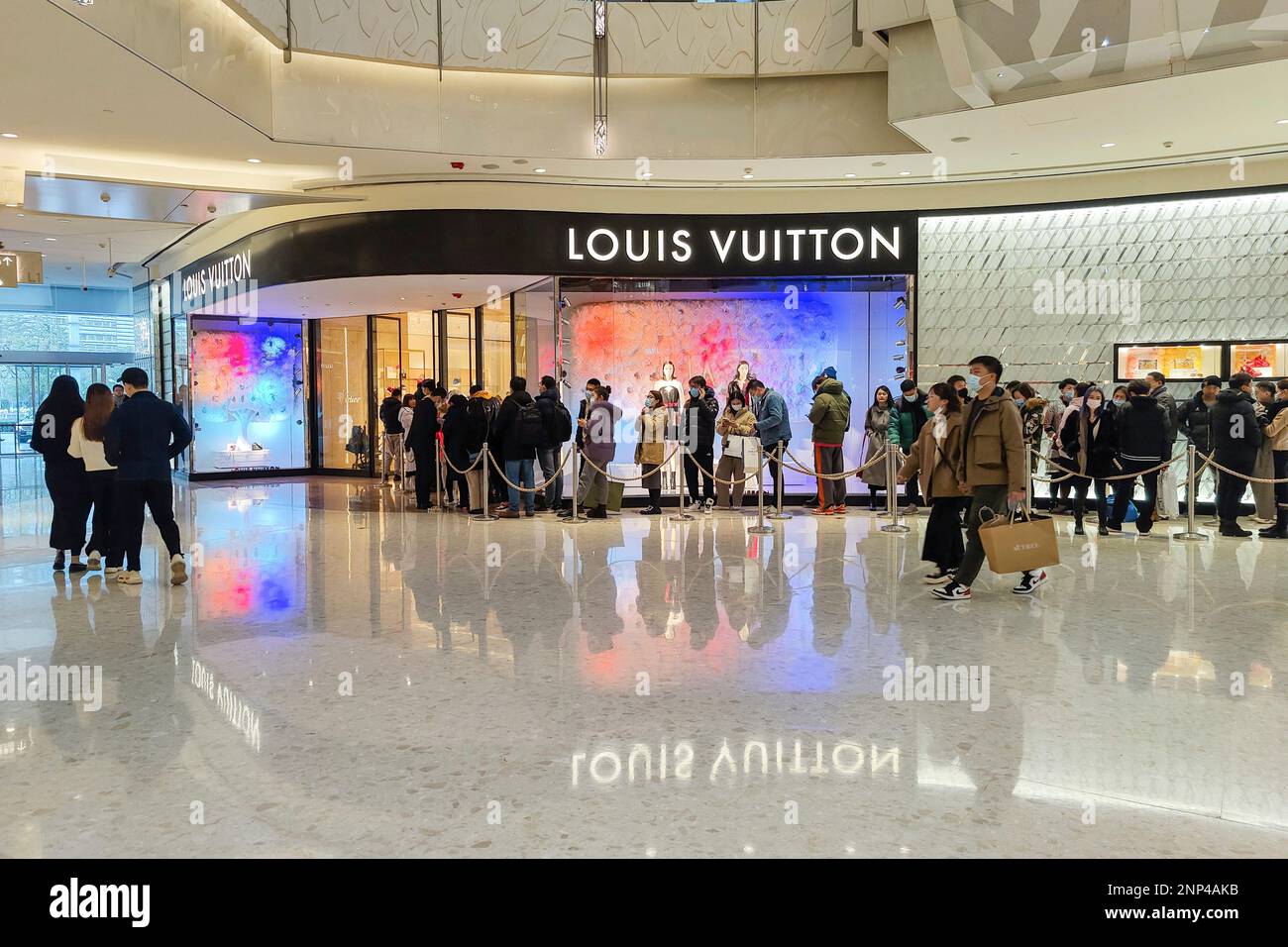 People line up in front of a Louis Vuitton store in Shanghai