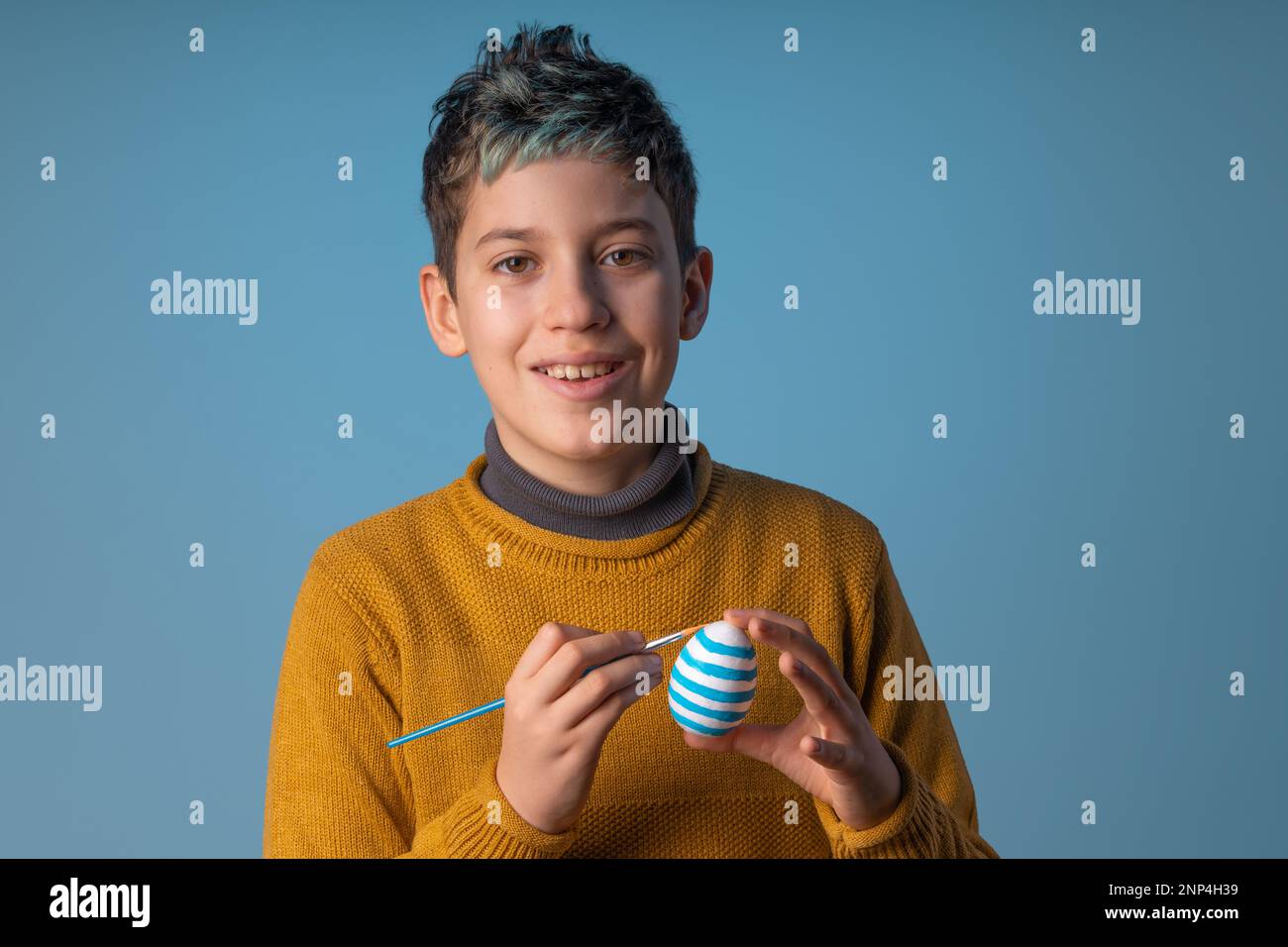 Happy 10yearold caucasian boy with blue hair covering one eye with a