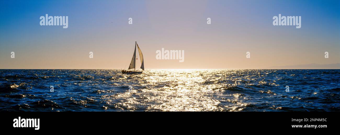 Sailboat sailing in ocean at sunset, Redondo Beach, California, USA