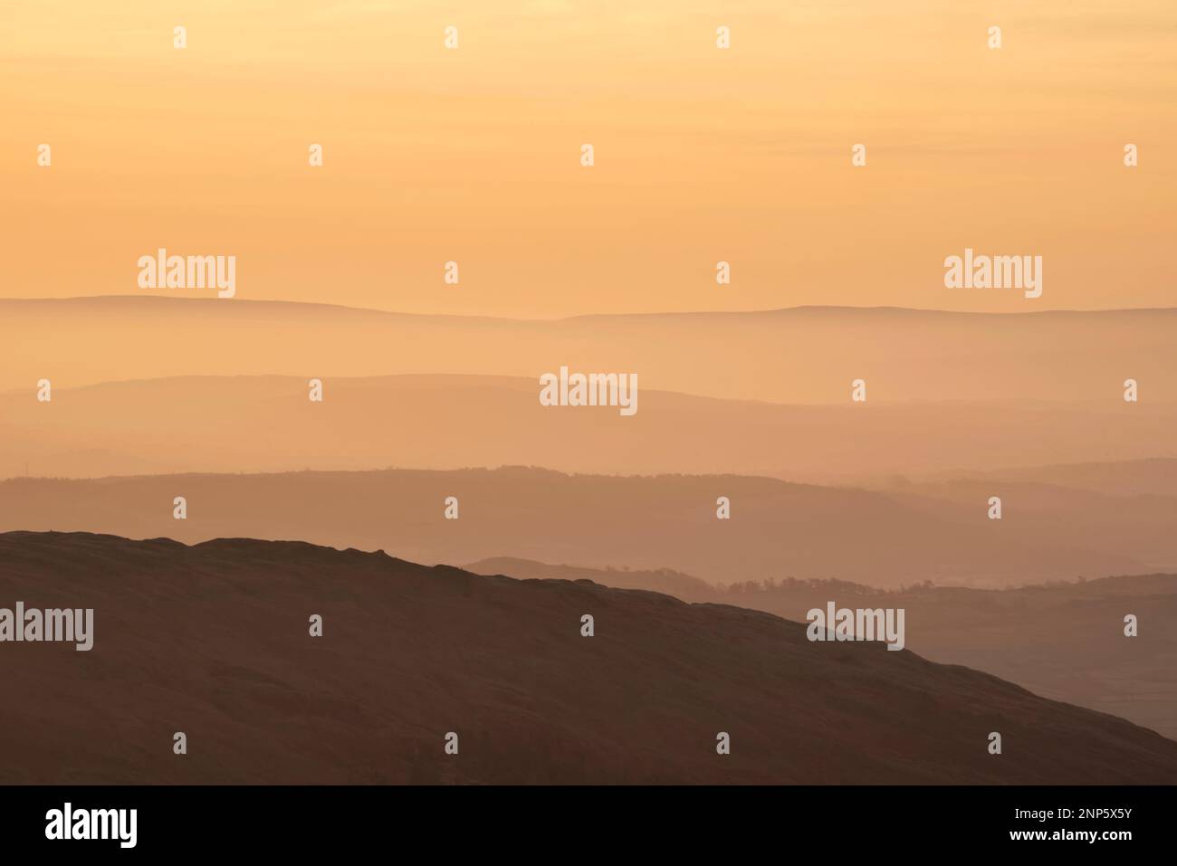 Lovely Winter landscape view from Red Screes across misty layers of