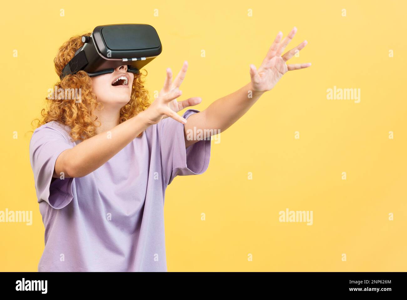Woman gesturing while using a virtual reality goggles Stock Photo
