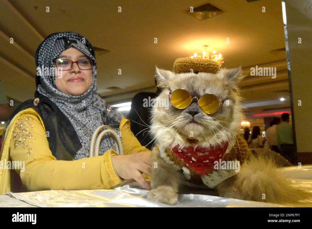 Dhaka. 26th Feb, 2023. A cat owner poses for photos with her cat during