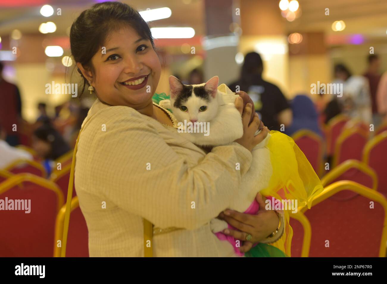 Dhaka. 26th Feb, 2023. A cat owner poses for photos with her cat during