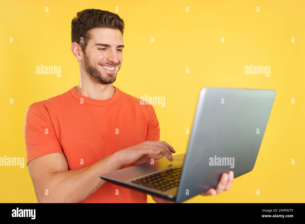 Caucasian man smiling while using a laptop Stock Photo