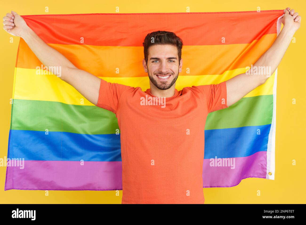 Happy caucasian man raising a lgbt rainbow flag Stock Photo - Alamy