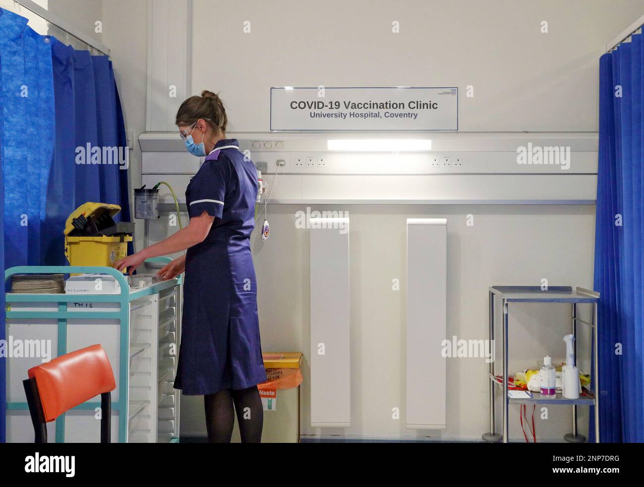 A nurse prepares a cubicle, as medical staff train to administer 