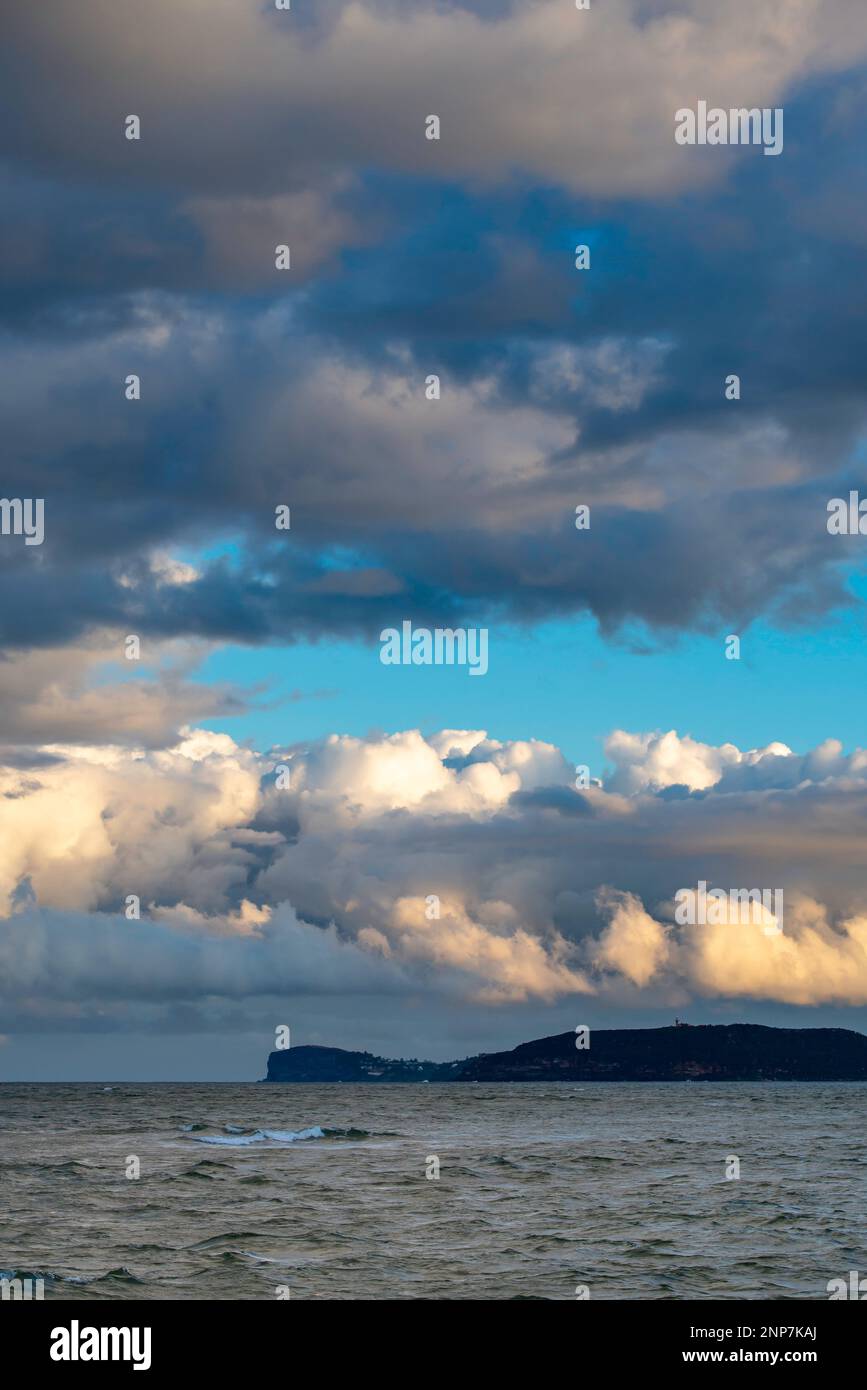 Large puffy and colourful clouds rolling north towards Ettalong Beach across Broken Bay and Lion Island from West Head in Sydney, Australia Stock Photo