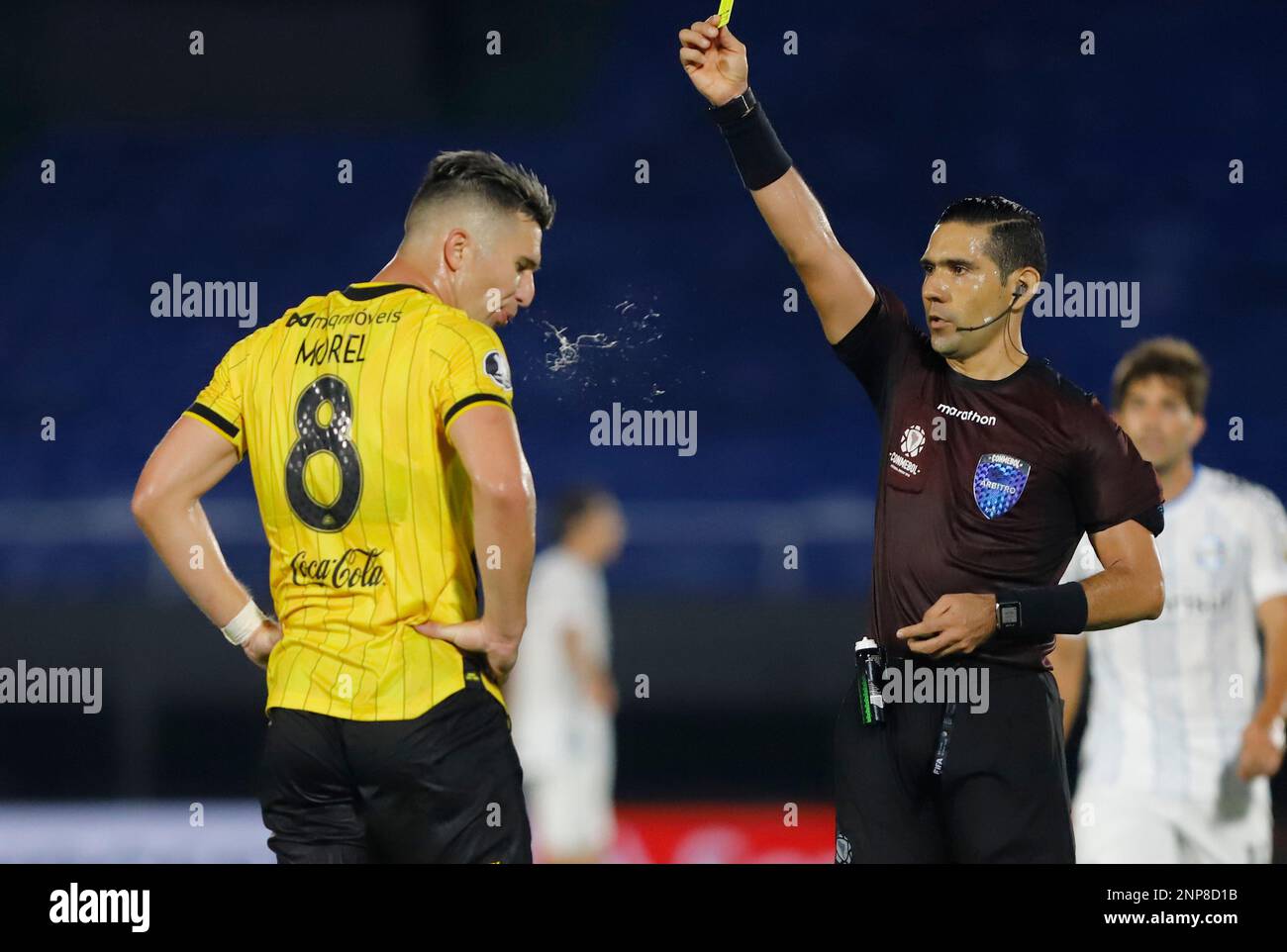 Referee Guillermo Guerrero shows the yellow card to Morel of