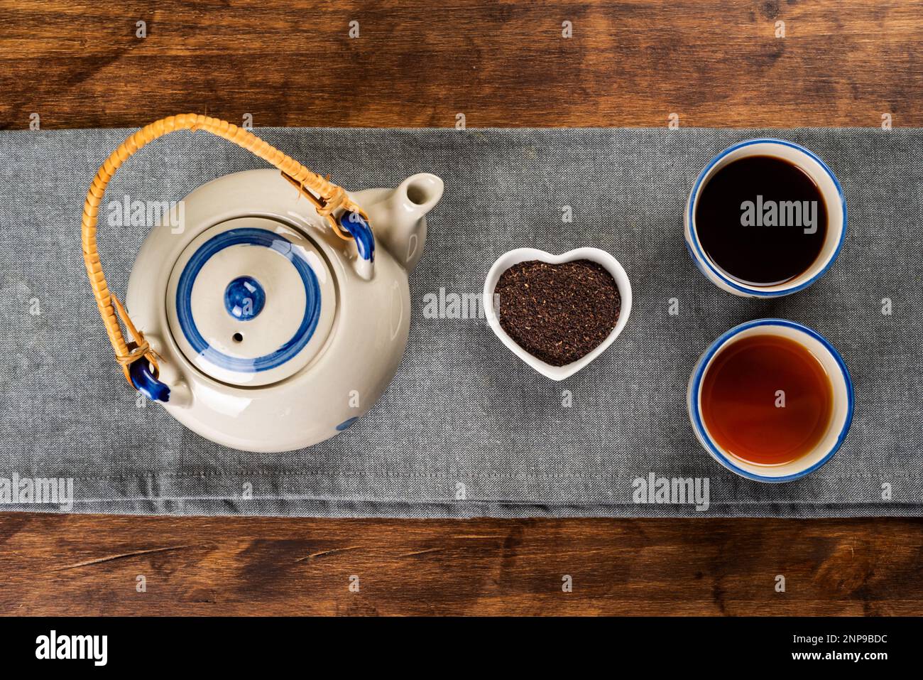 Porcelain teapot next to a small heartshaped bowl with ground tea, two