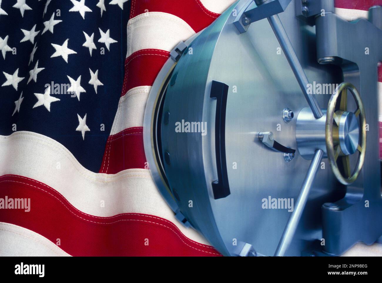 OPEN BANK SAFE VAULT DOOR WITH WALL OF UNITED STATES OF AMERICA FLAG Stock Photo