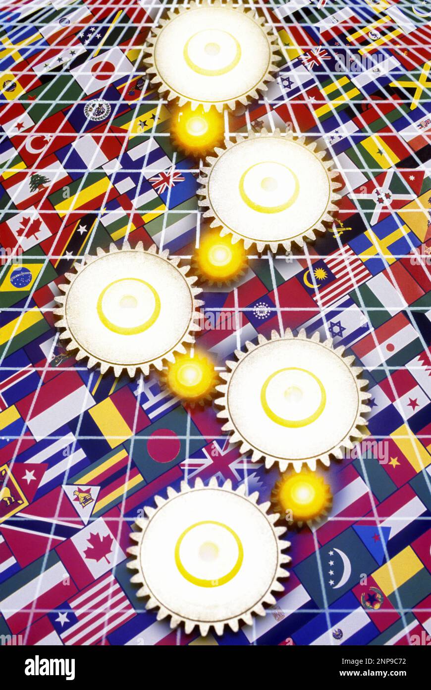 INTERLOCKING COG GEARS OVER NATIONAL FLAGS Stock Photo