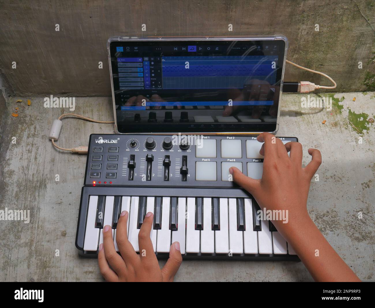 hand playing midi controller and music editing with android application Stock Photo