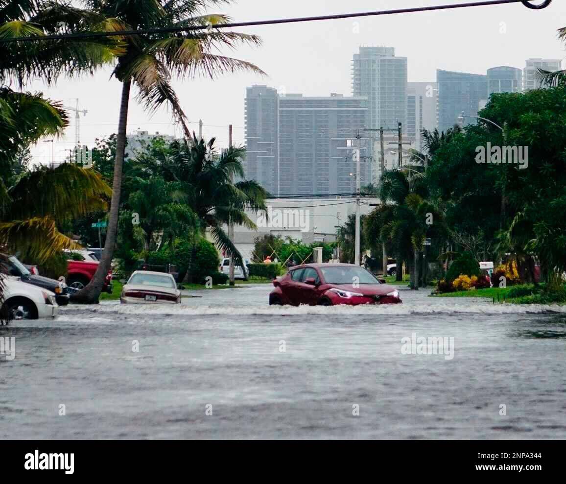 A car navigates a flooded street in the Melrose Manors neighborhood