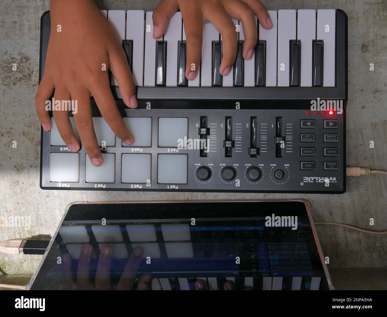 hand playing midi controller and music editing with android application
