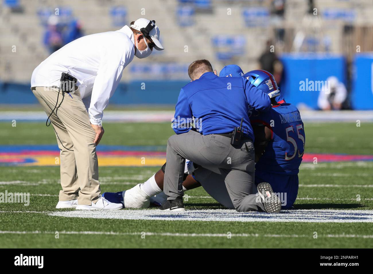 LAWRENCE, KS - OCTOBER 31: Kansas Jayhawks head coach Les Miles checks on  injured offensive lineman Armaj Adams-Reed (55) in the fourth quarter of a  Big 12 football game between the Iowa