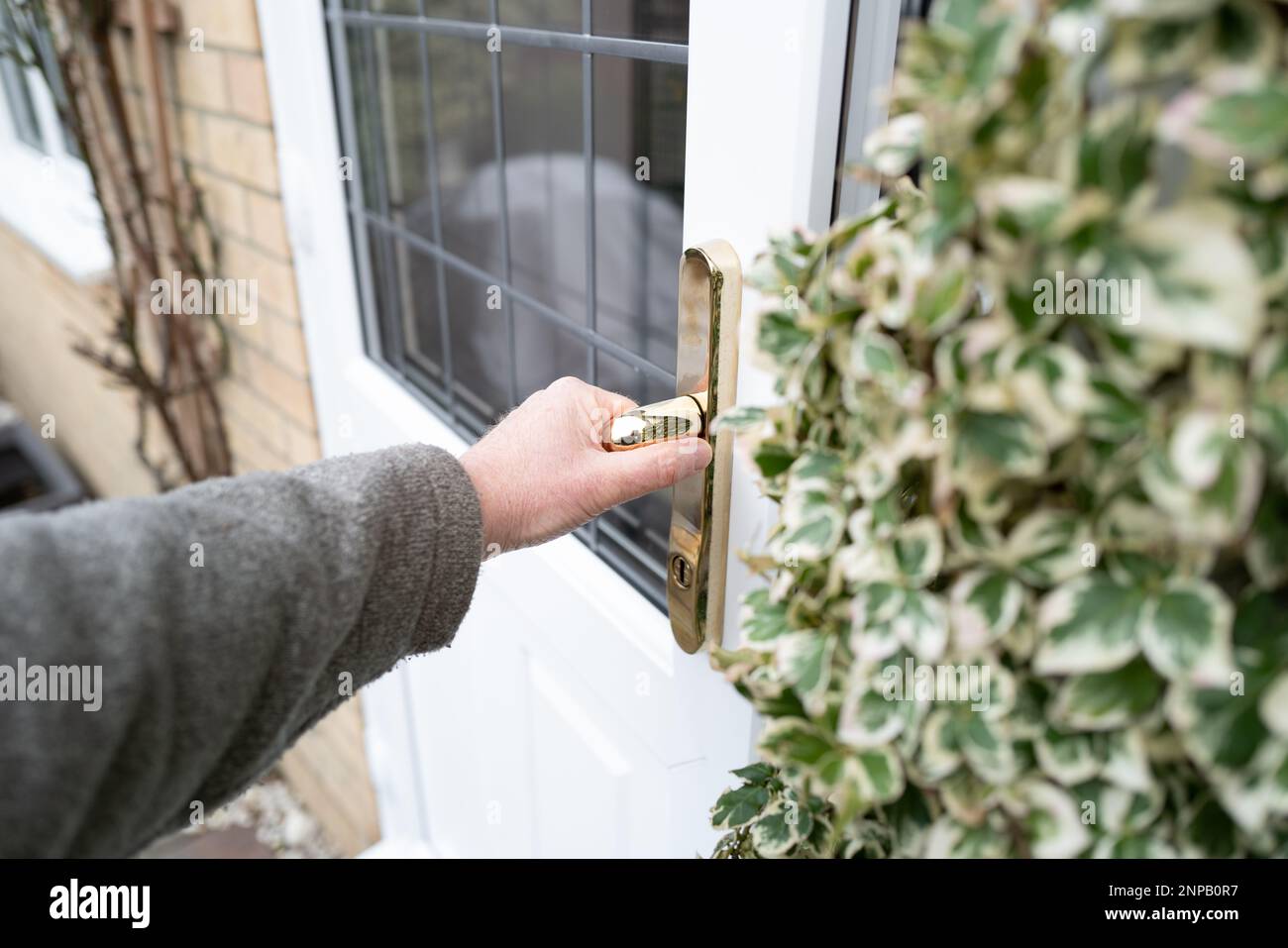 Shallow focus of a home owner opening a newly installed, energy conserving double glazed door at the rear of a home. Stock Photo