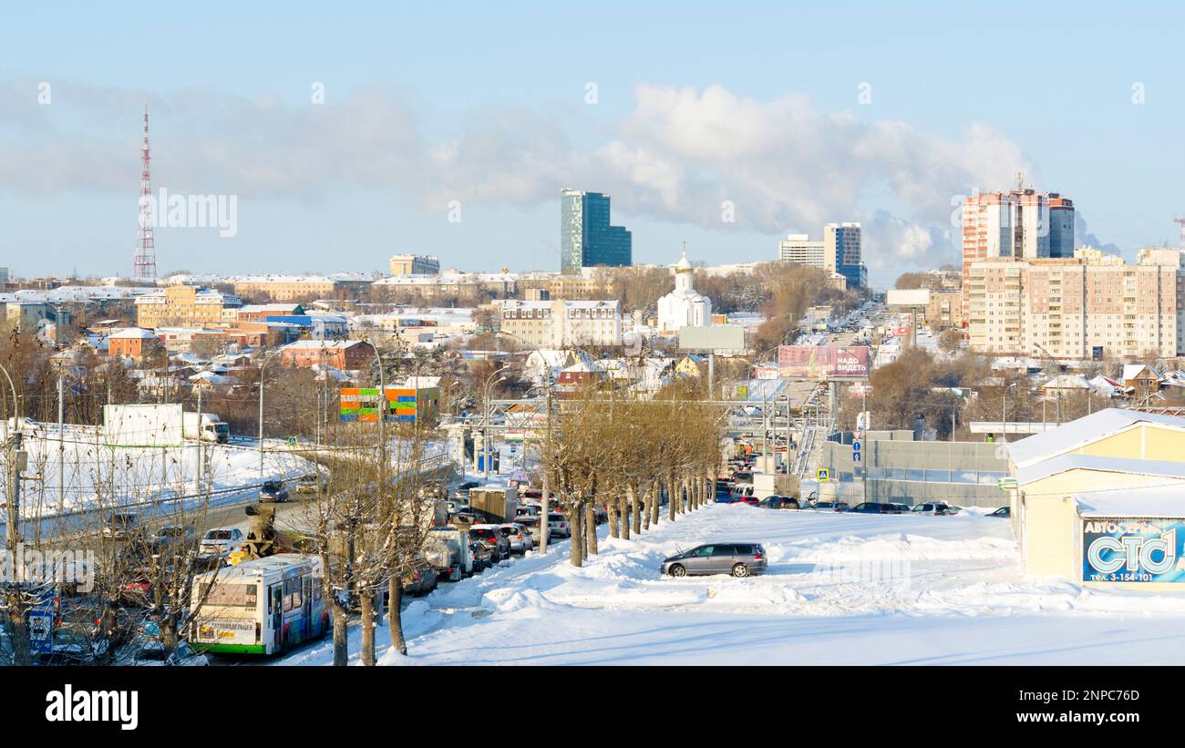 Many cars stand in a traffic jam on a winter road on the street of the city of Novosibirsk in Russia in the spring afternoon. Stock Photo