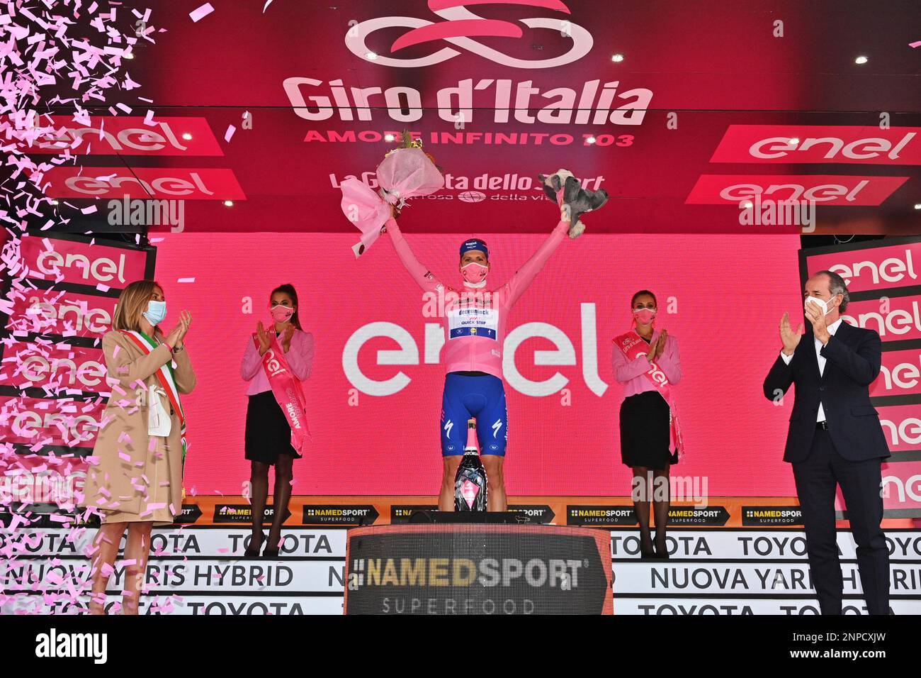Joao Almeida wears the pink jersey of the race overall leader as he celebrates on the podium