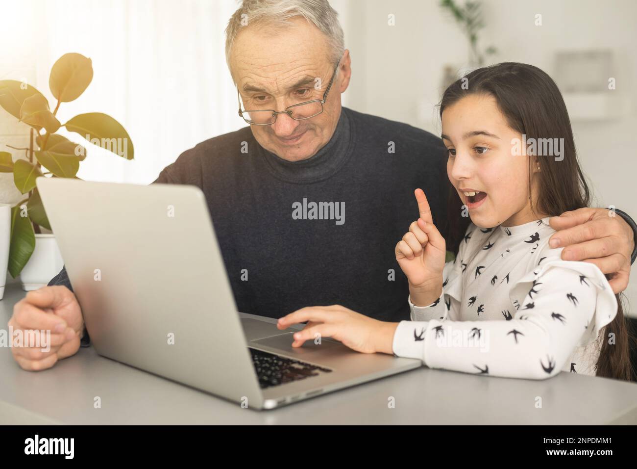 Grandfather and granddaughter spend time together use laptop, browse