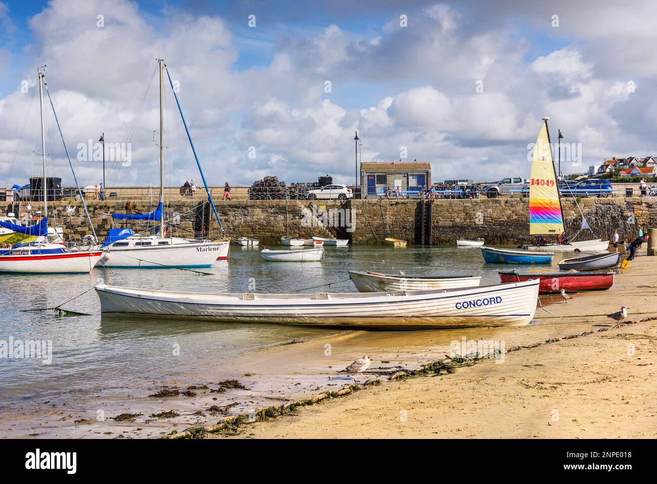 A traditional Cornish Pilot Gig beached on the beach in the historic picturesque working Newquay Harbour in Newquay on the North Cornwall coast. Stock Photo