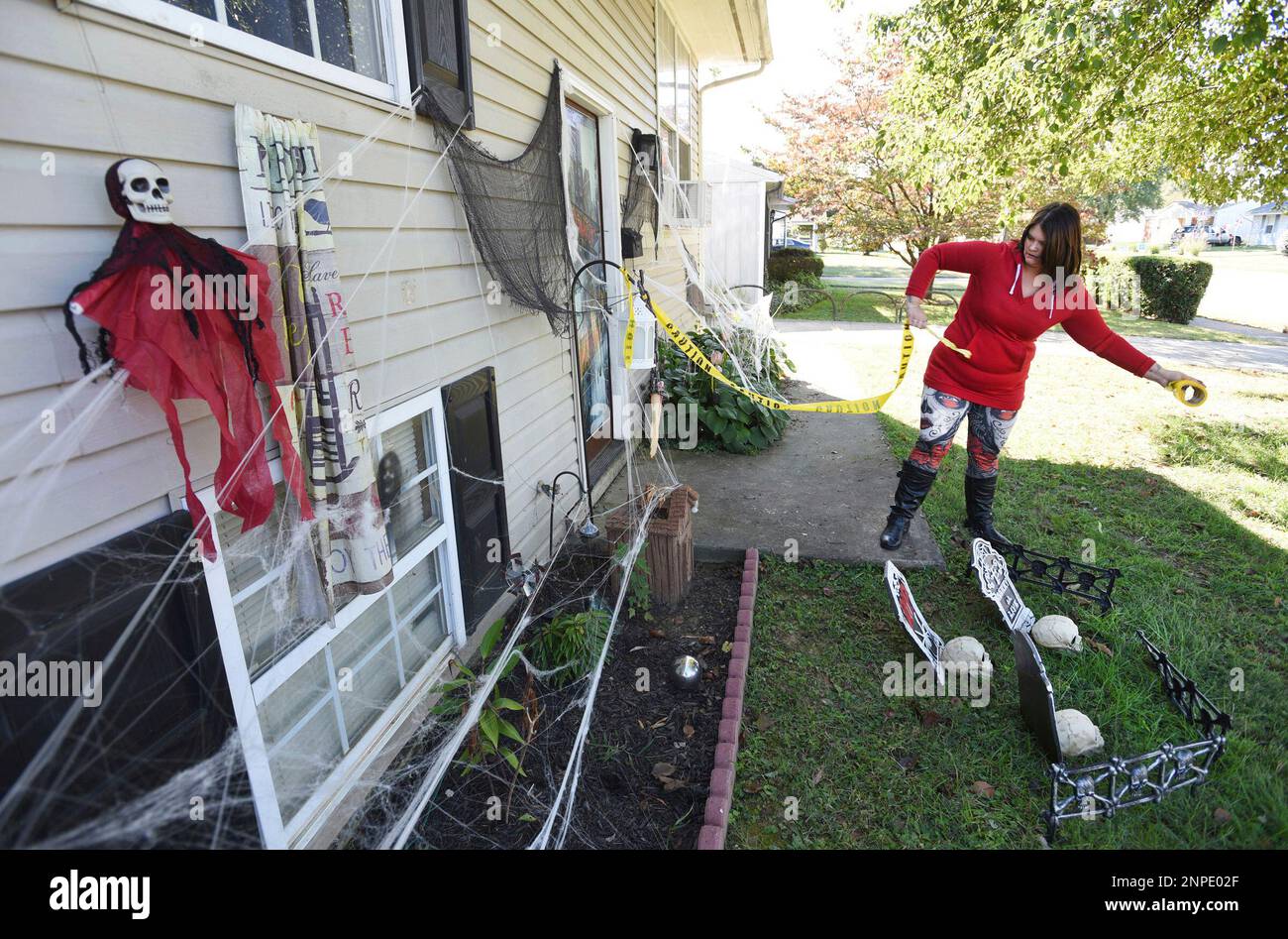 Christa Walker decorates the front of her house with yellow caution tape  for Halloween in the 600 block of Carter Road in Owensboro, Ky., on Monday,  Oct. 5, 2020. Walker is hoping