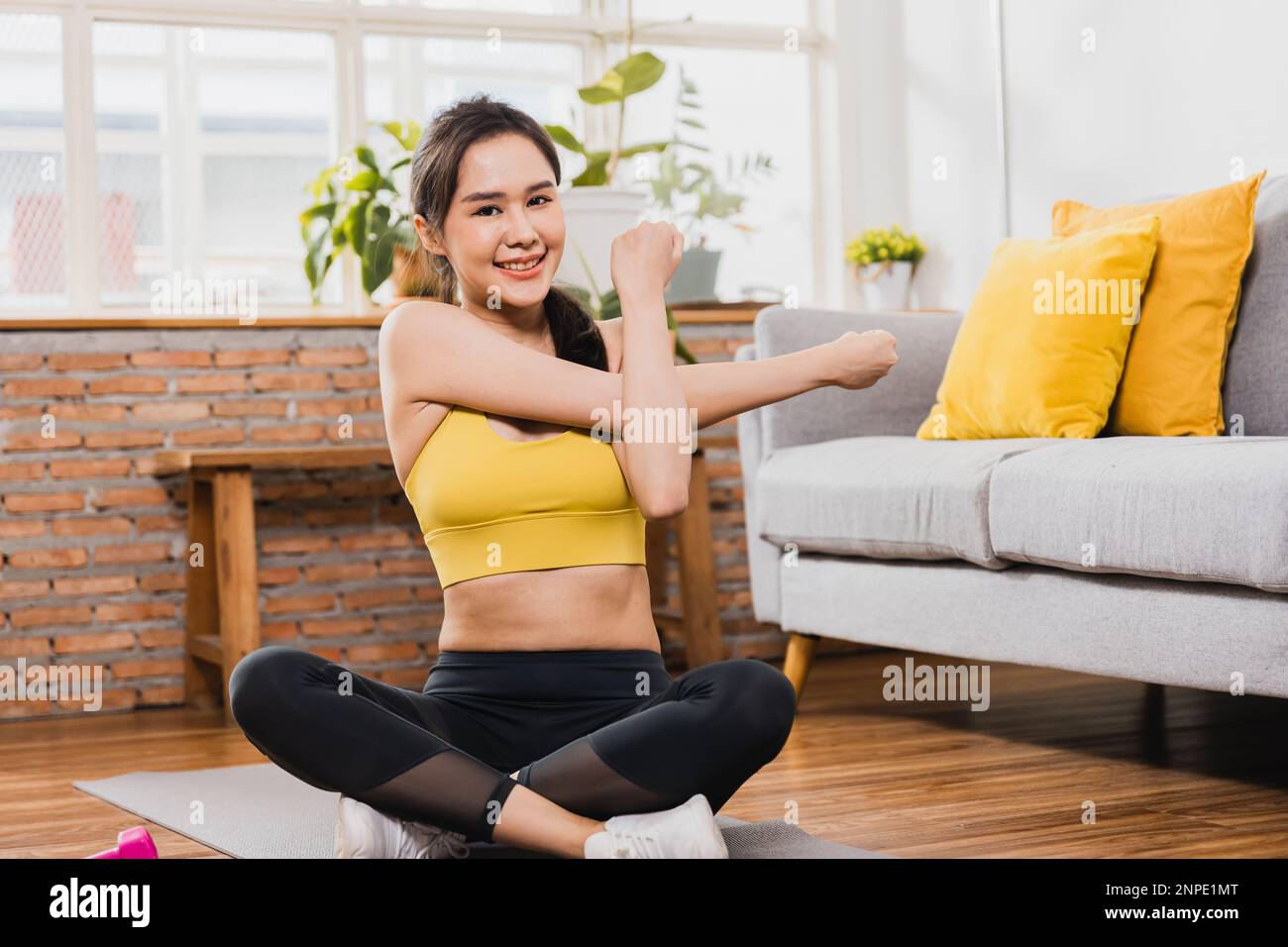 Sporty young woman, Asian female exercising with her weights in the living room Stock Photo
