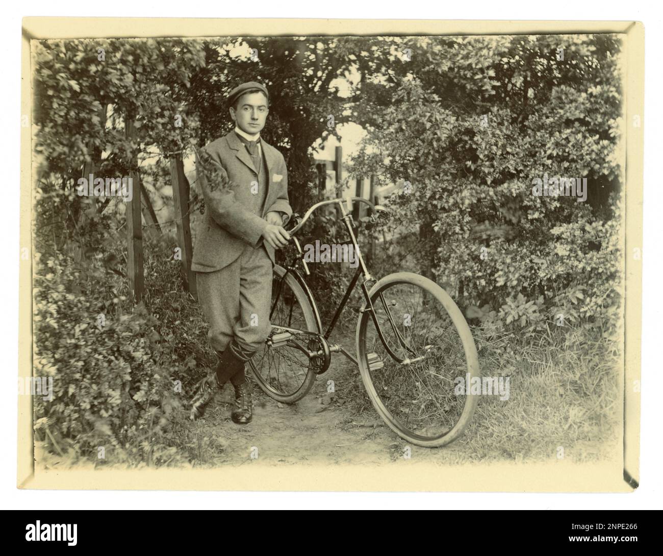 Original Victorian photograph of a young man with his bicycle in a garden,, vintage cycling,  circa 1898, U.K. Stock Photo