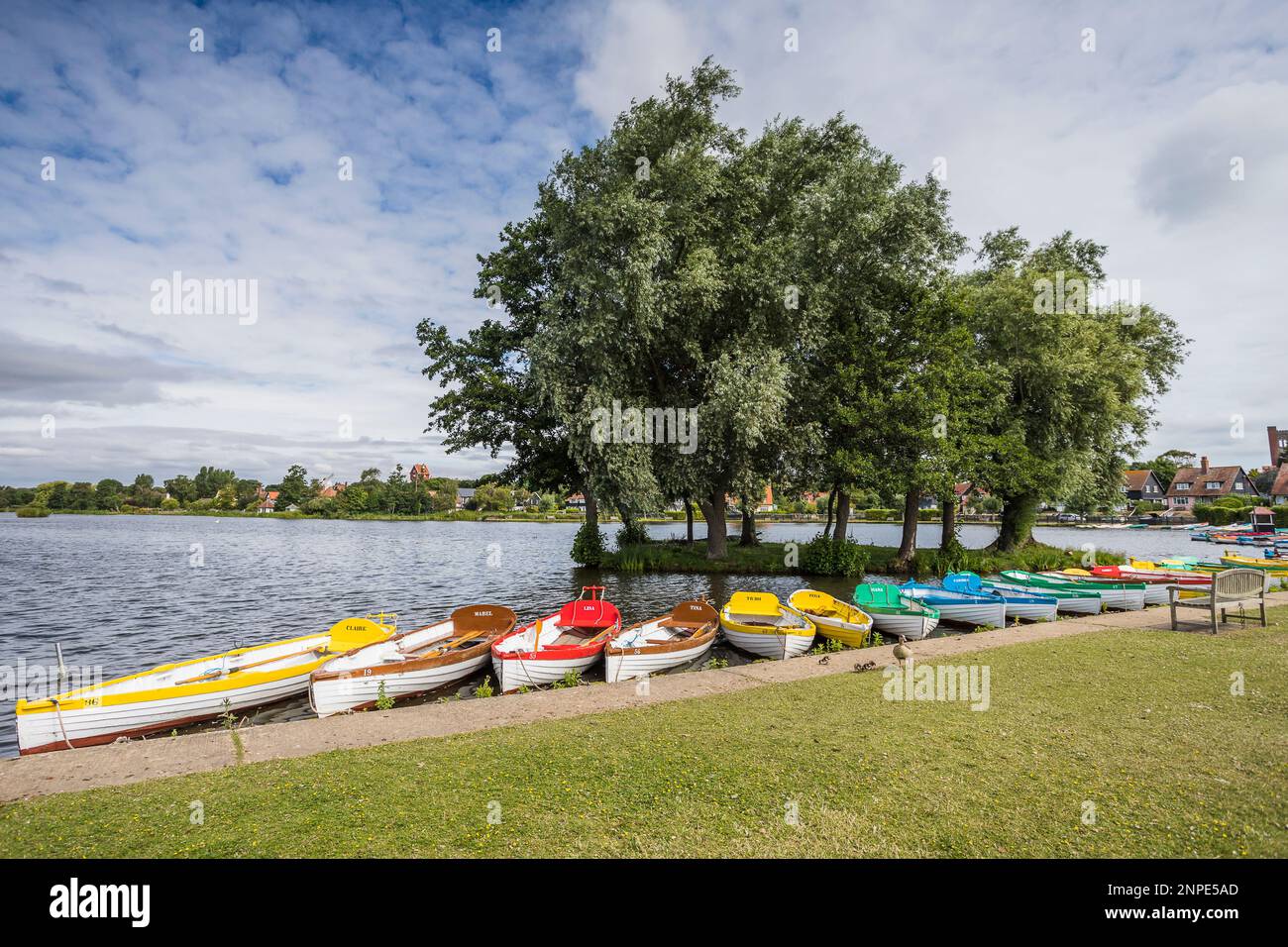The pretty mere at Thorpeness framed by colourful rowing boats on the Suffolk coastline. Stock Photo