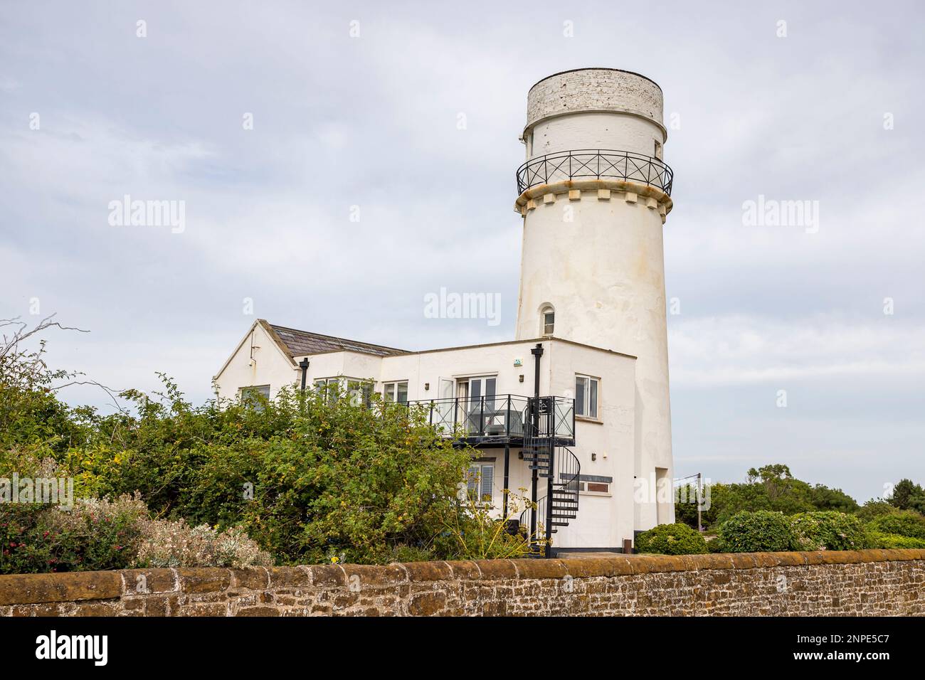 Hunstanton lighthouse on the West Norfolk coast behind a rustic wall on the seafront. Stock Photo