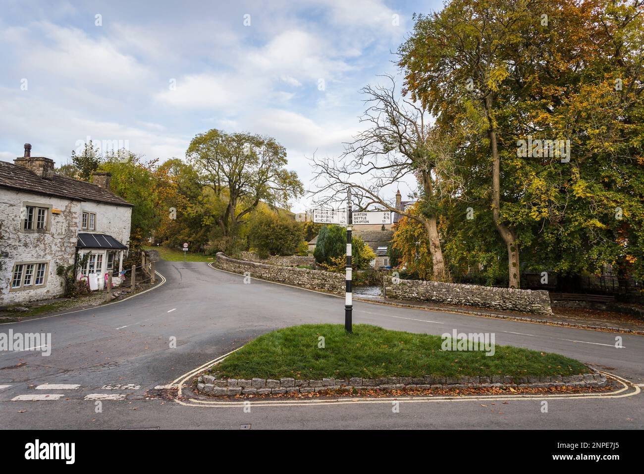 An old sign post on a grass triangle in the village of Malham. Stock Photo