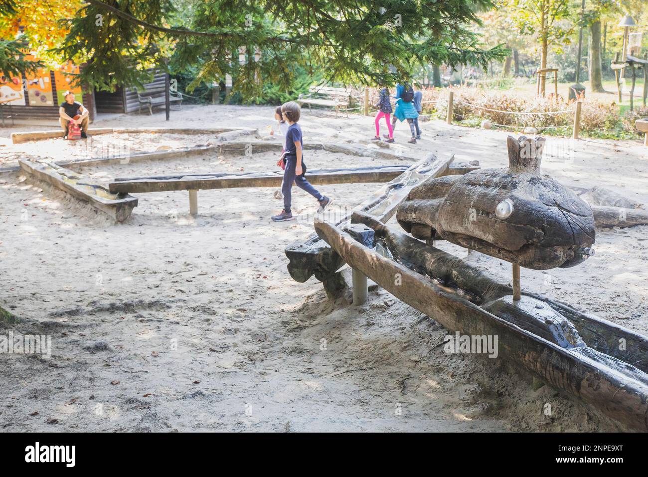 Drinking fountain in the form of a huge wooden snake at the playground Stock Photo