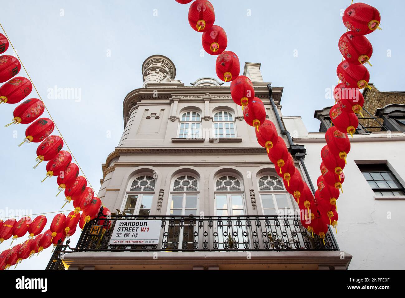 In Chinatown in London, fresh red lanterns are hung from the buildings to celebrate the Chinese New Year. This image shows the mix of eastern and west Stock Photo