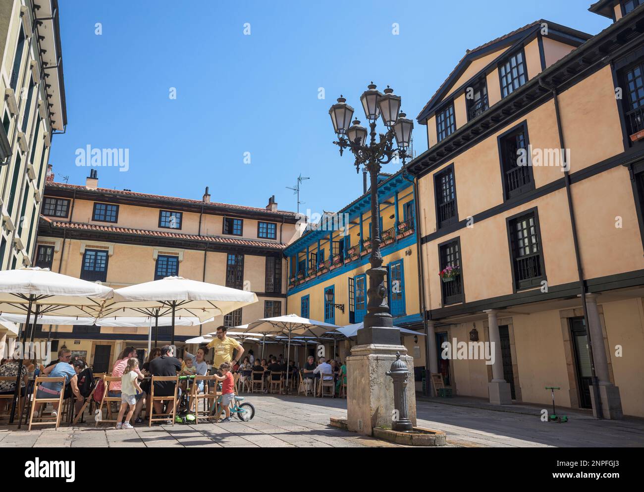 A bustling downtown plaza in Oviedo, Spain surrounded by stunning architecture and clear blue skies. Stock Photo