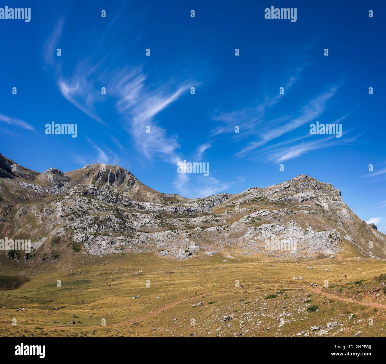 A majestic mountain range in Somiedo Natural Park, Asturias surrounded by blue skies and fluffy clouds - a stunning example of natures beauty. Stock Photo