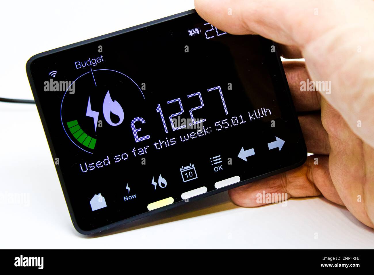 Hand Holding a Smart Meter Monitor Showing Current Week Energy Usage for Gas and Electricity Combined With Cost in Pound Sterling Stock Photo