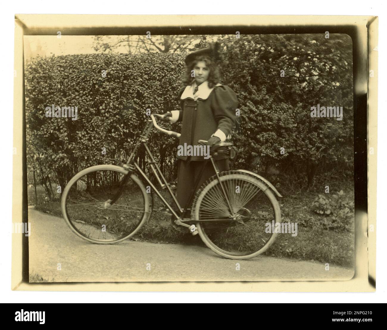 Original Victorian photograph of a teenager with her bicycle in a garden, wearing a beret, , vintage cycling,  circa 1897, Worcester area, U.K Stock Photo