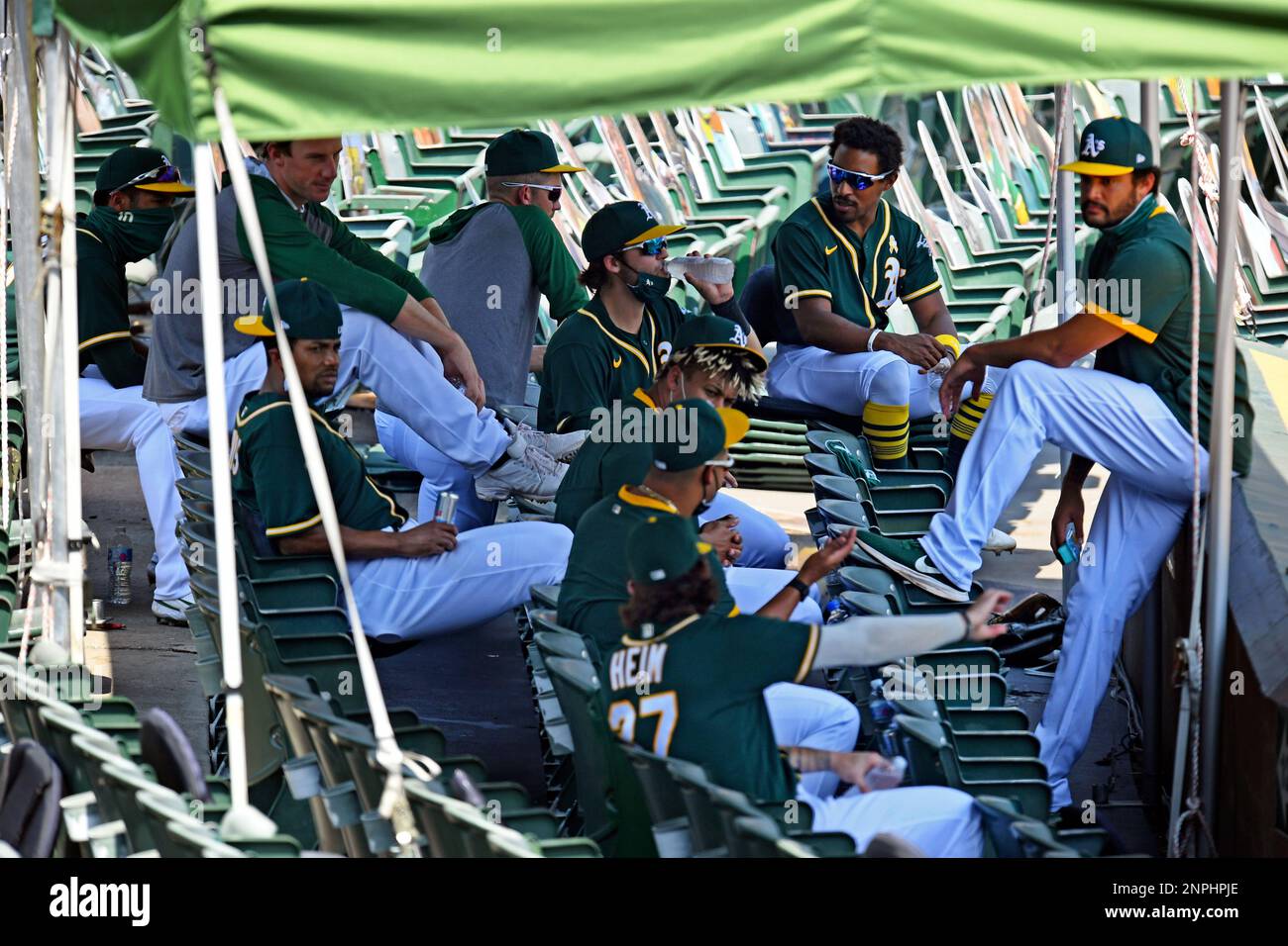 Oakland Athletics players take refuge under a tent as they keep hydrated  while playing the San Diego Padres in the first inning of a baseball game  in Oakland, Calif., Sunday, Sept. 6,