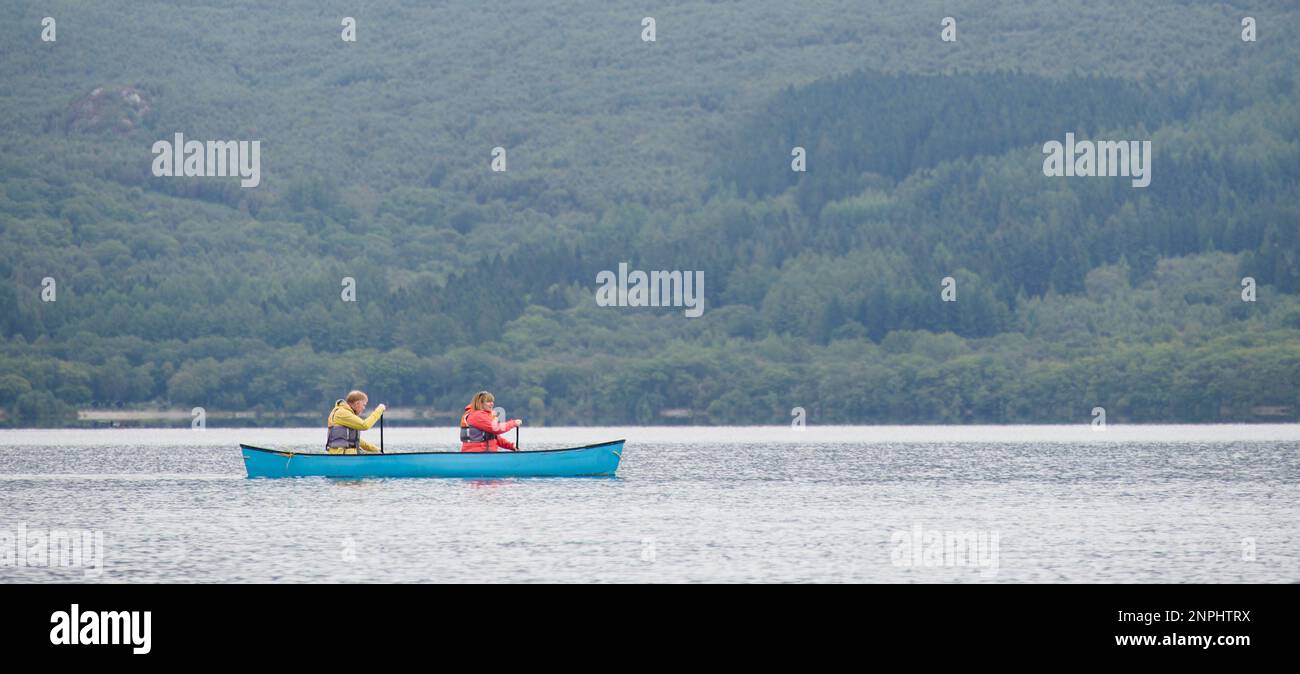 Canoe rowing across Loch Lomond during dull wet weather Stock Photo Alamy