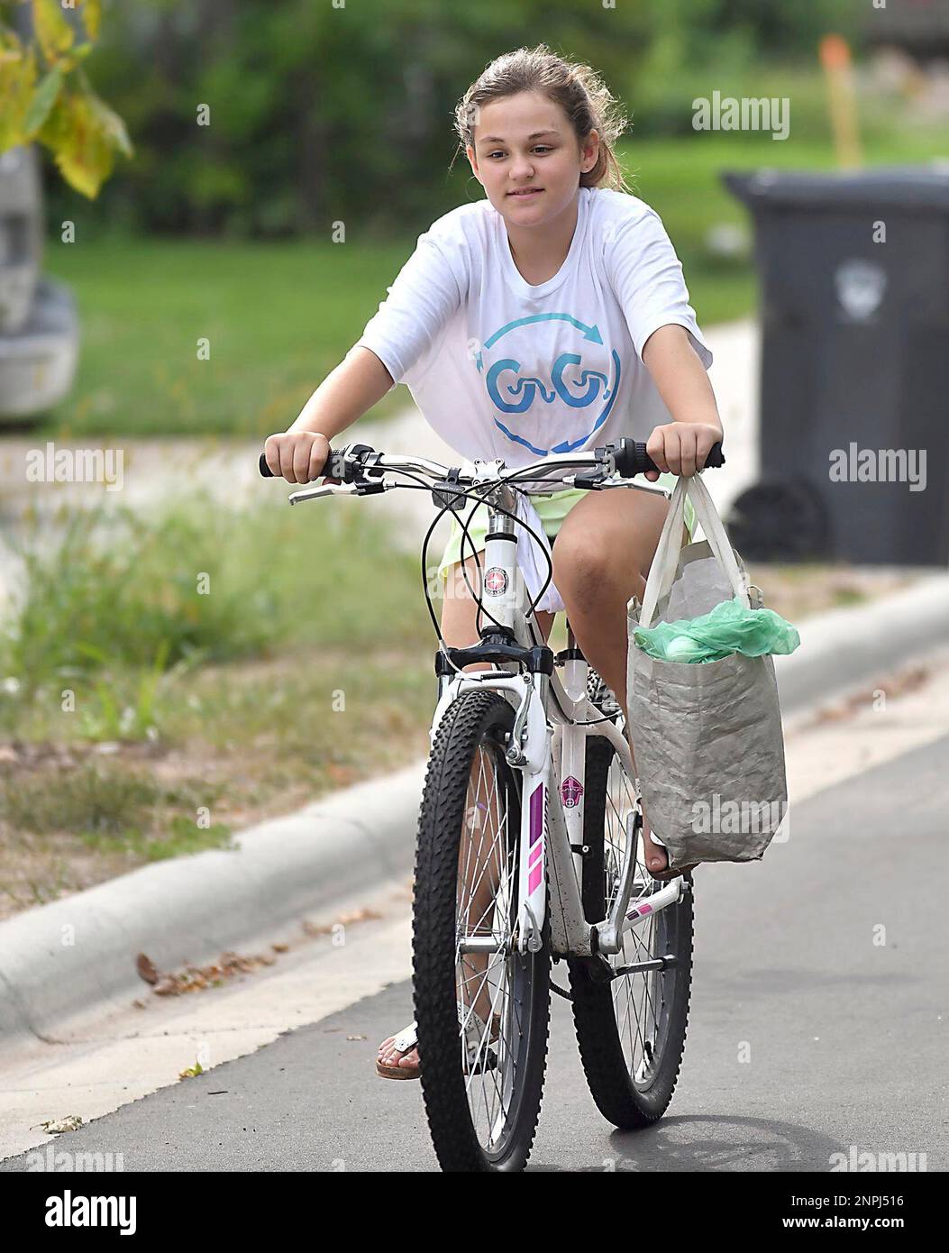 Evie Bottner, 11, returns from collecting organic recycling from a neighbor Thursday, Aug. 27