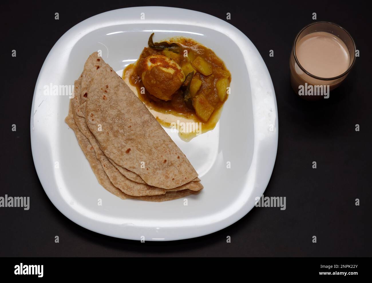 Indian Breakfast Chappathi, Egg Roast And Tea In Black Background Stock Photo