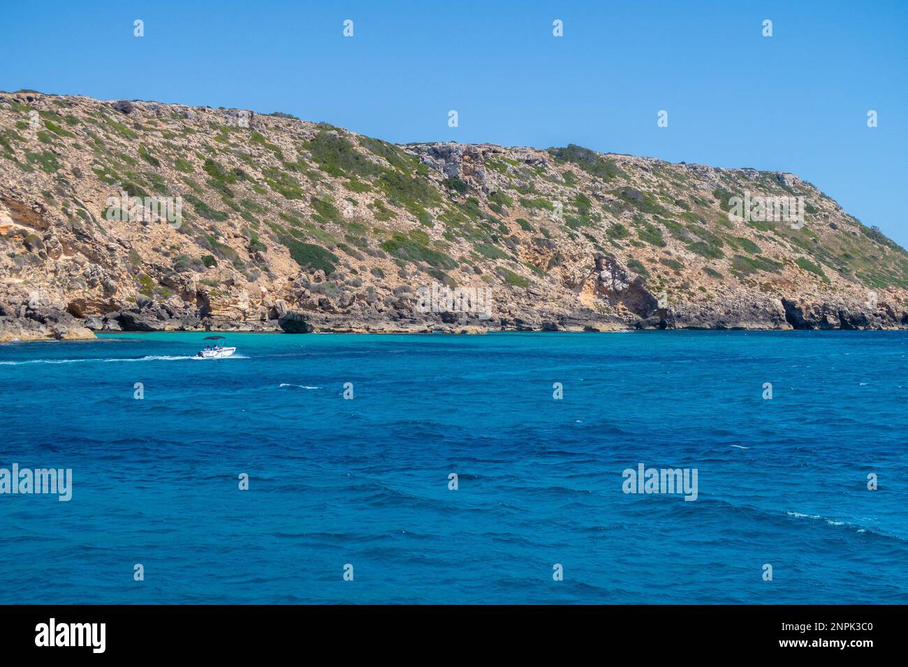 The coast of Majorca, showing the sea, hills and a speedboat Stock Photo