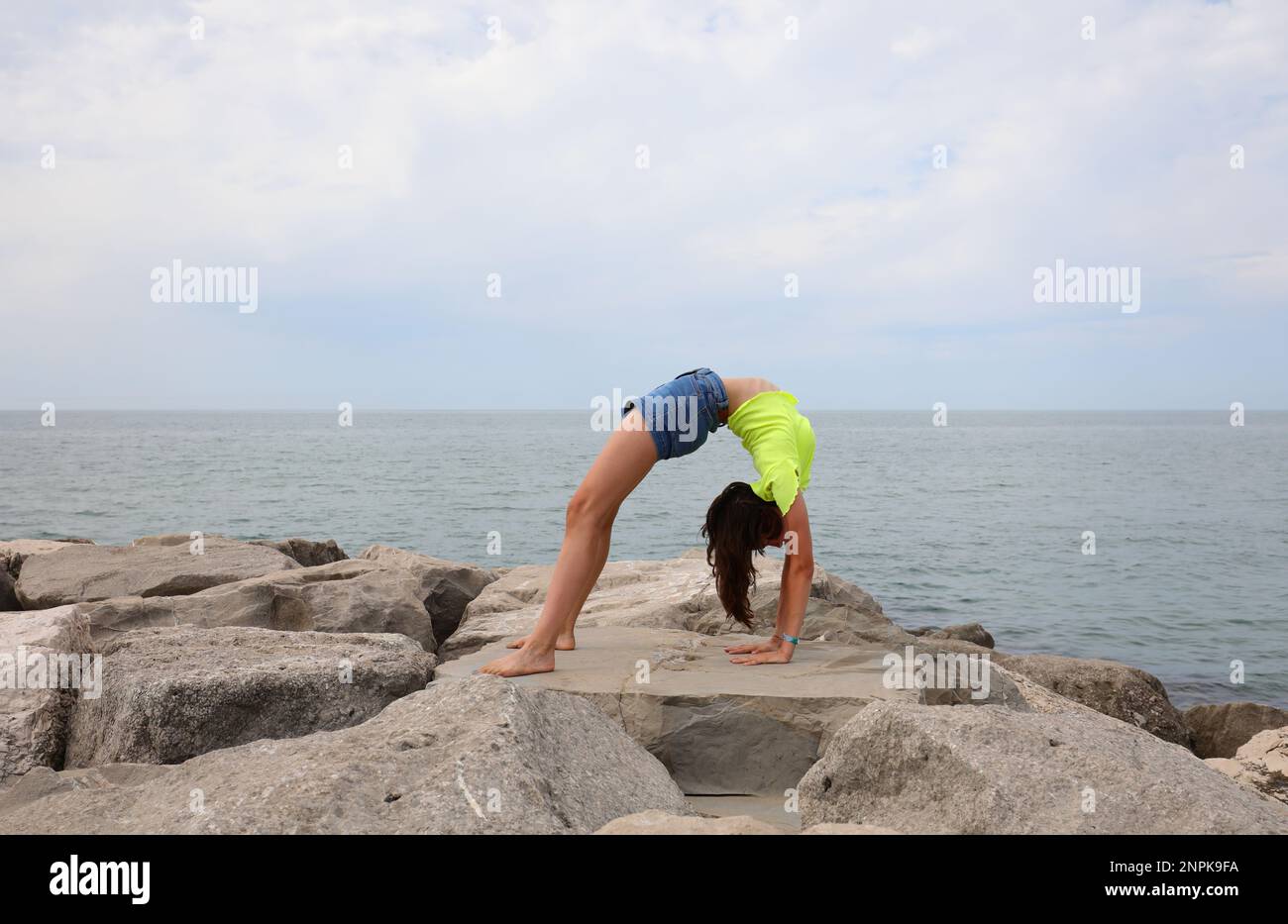 slender athletic girl performs gymnastic exercises arching her back on ...