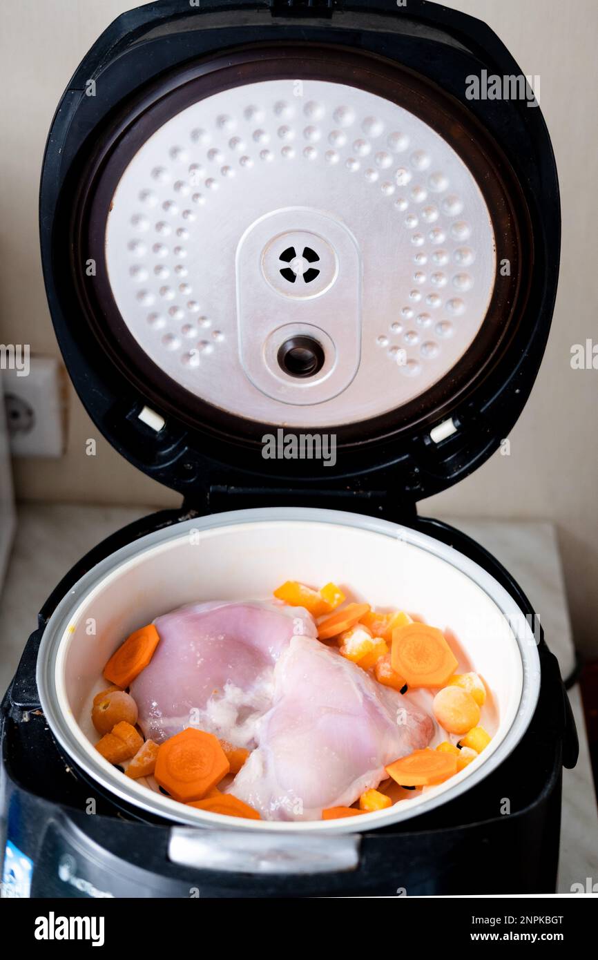 chicken meat and carrot pieces in a double boiler, top view. Steamed meat and vegetables Stock Photo