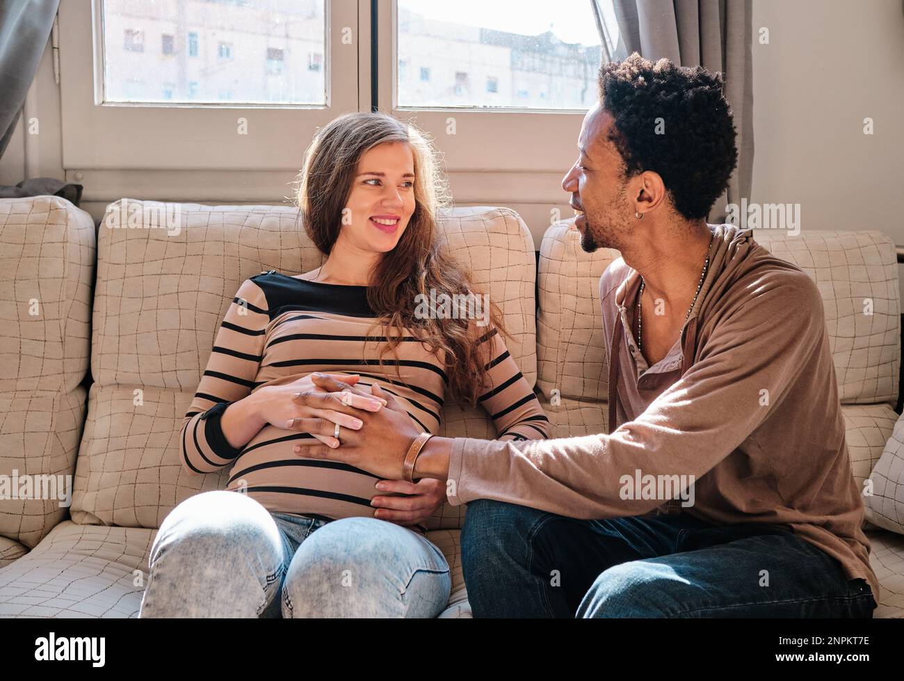 Happy multiethnic couple smiling while expecting a baby Stock Photo - Alamy