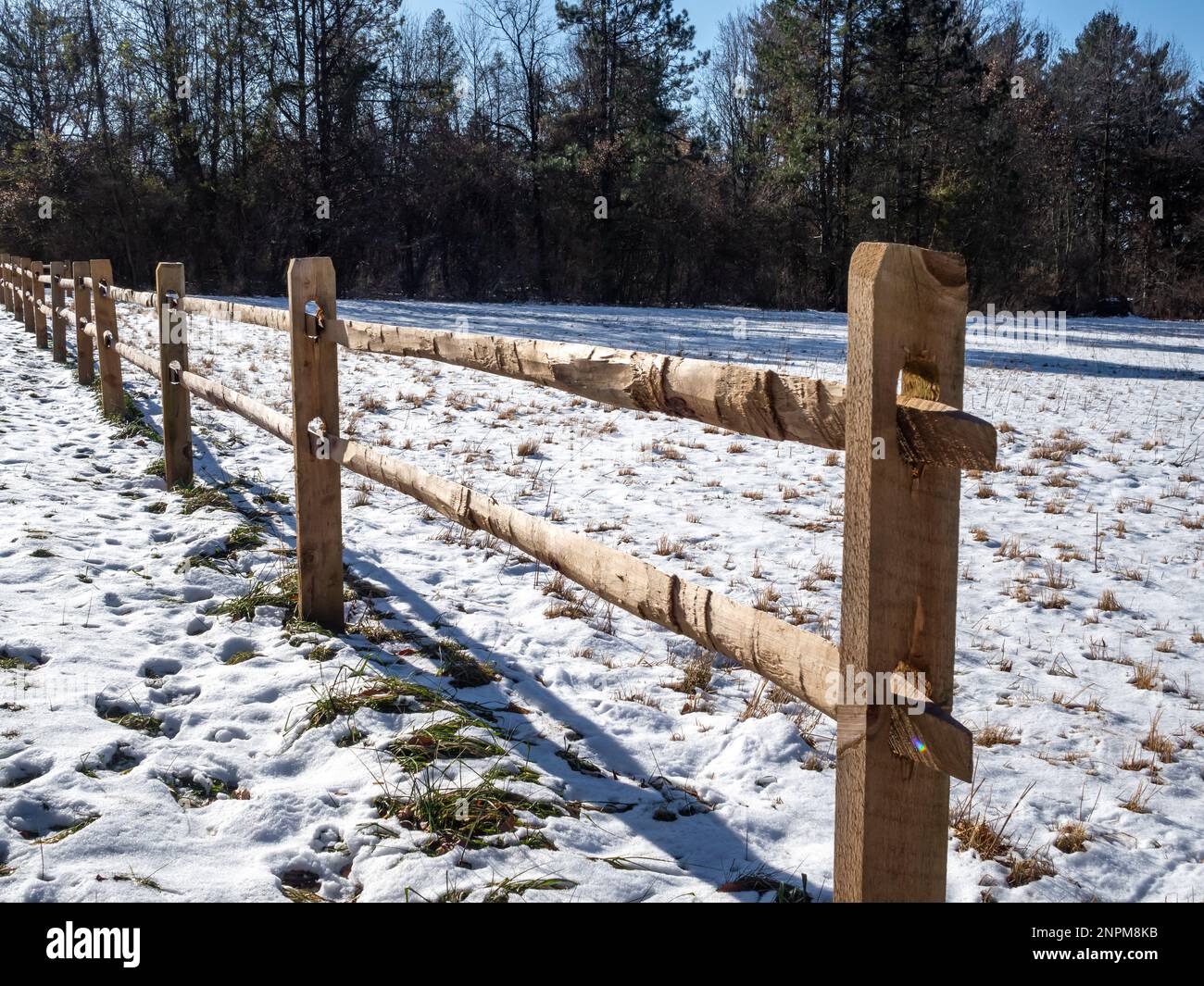 wooden fence in the reservation covered with snow in winter Stock Photo