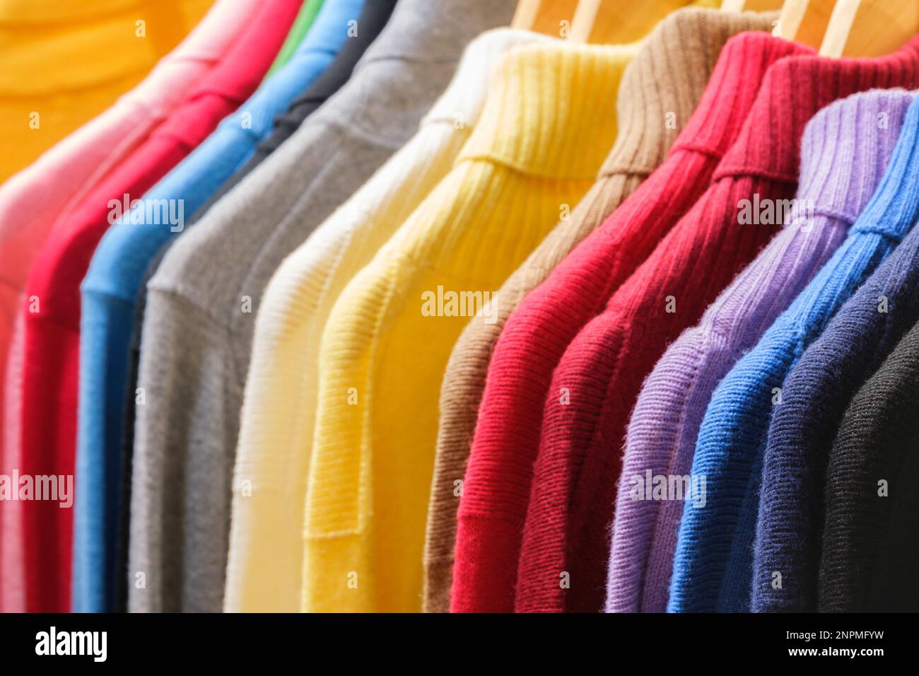 Fashion clothes on clothing rack - bright colorful closet. Closeup