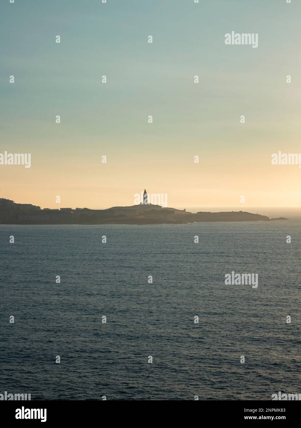 Tower of Hercules on the horizon, illuminated by the last rays of sunlight at sunset. Located in A Coruña, Galicia, and of historical interest, copy s Stock Photo