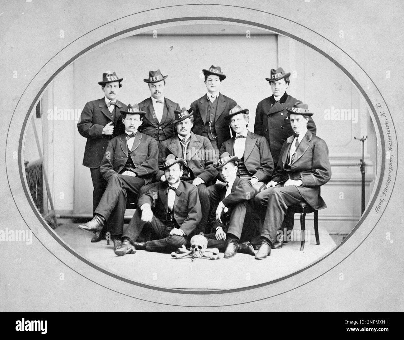 Ku Klux Klan, Watertown Division 289, Watertown, N.Y.   c1870. Ten men posed seated and standing, wearing hats with 'KKK' in large letters, and with a skull and bones arranged on the floor in front of them. Stock Photo